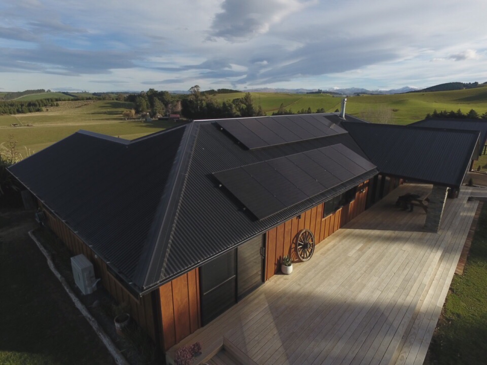Rural New Zealand home with a full black solar array across its roof